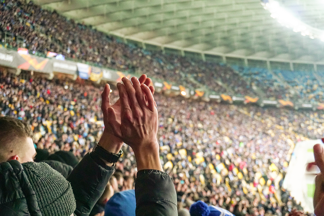 Close up of mans hands clapping at a sports event